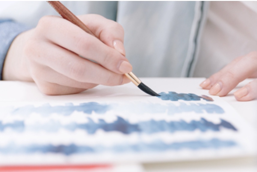 Painter applying blue watercolour paint.