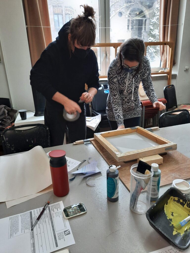 Two workshop participants work on screenprinting