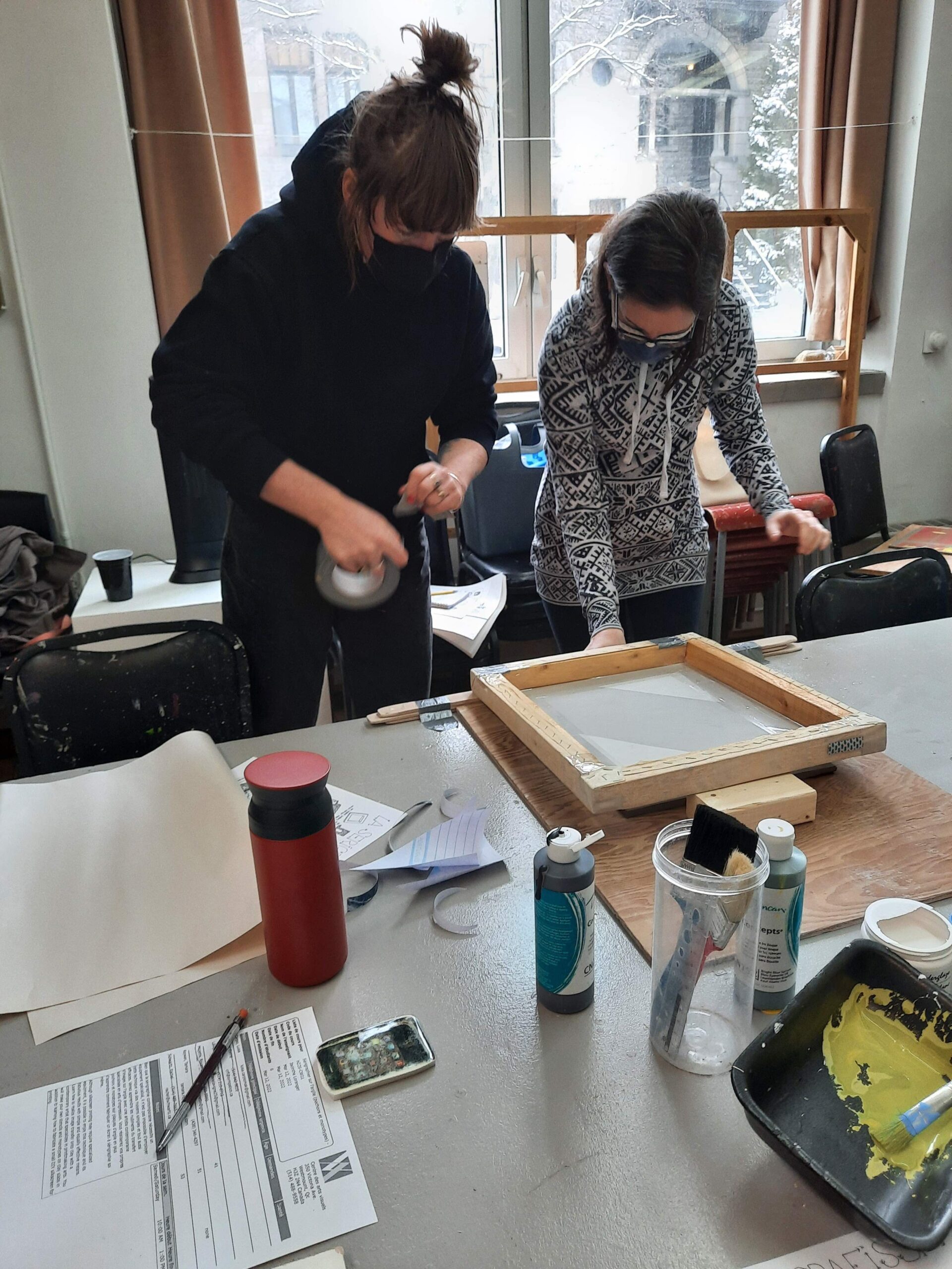 Two workshop participants work on screen printing.