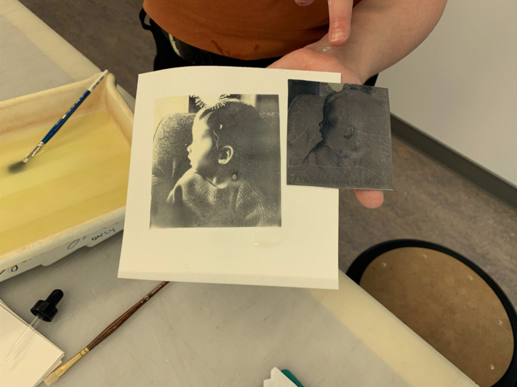 A Polaroid negative and an image of a young boy on paper.