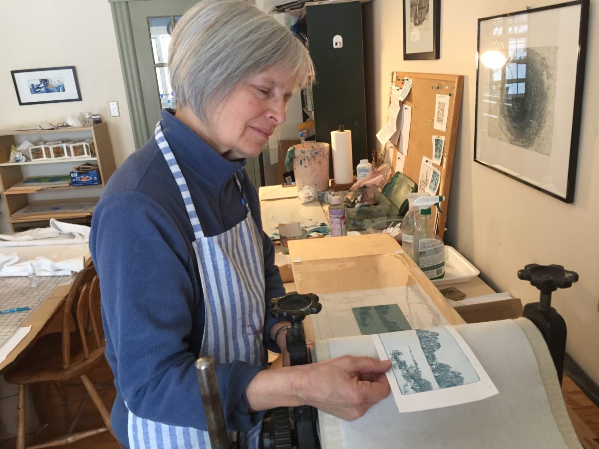Diana Baldwin holds up one of her etchings.